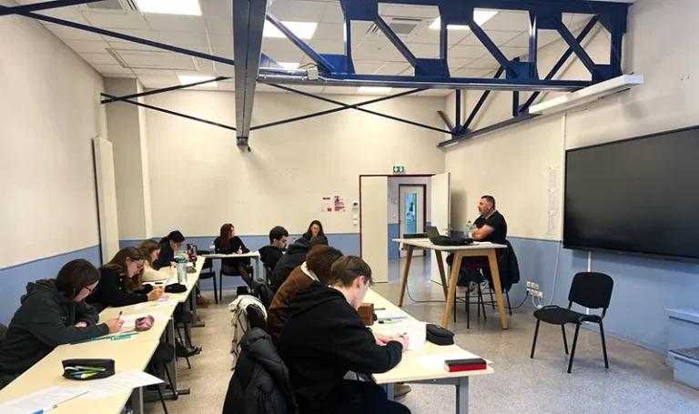 Un enseignant anime une séance de travail dans une salle de cours.