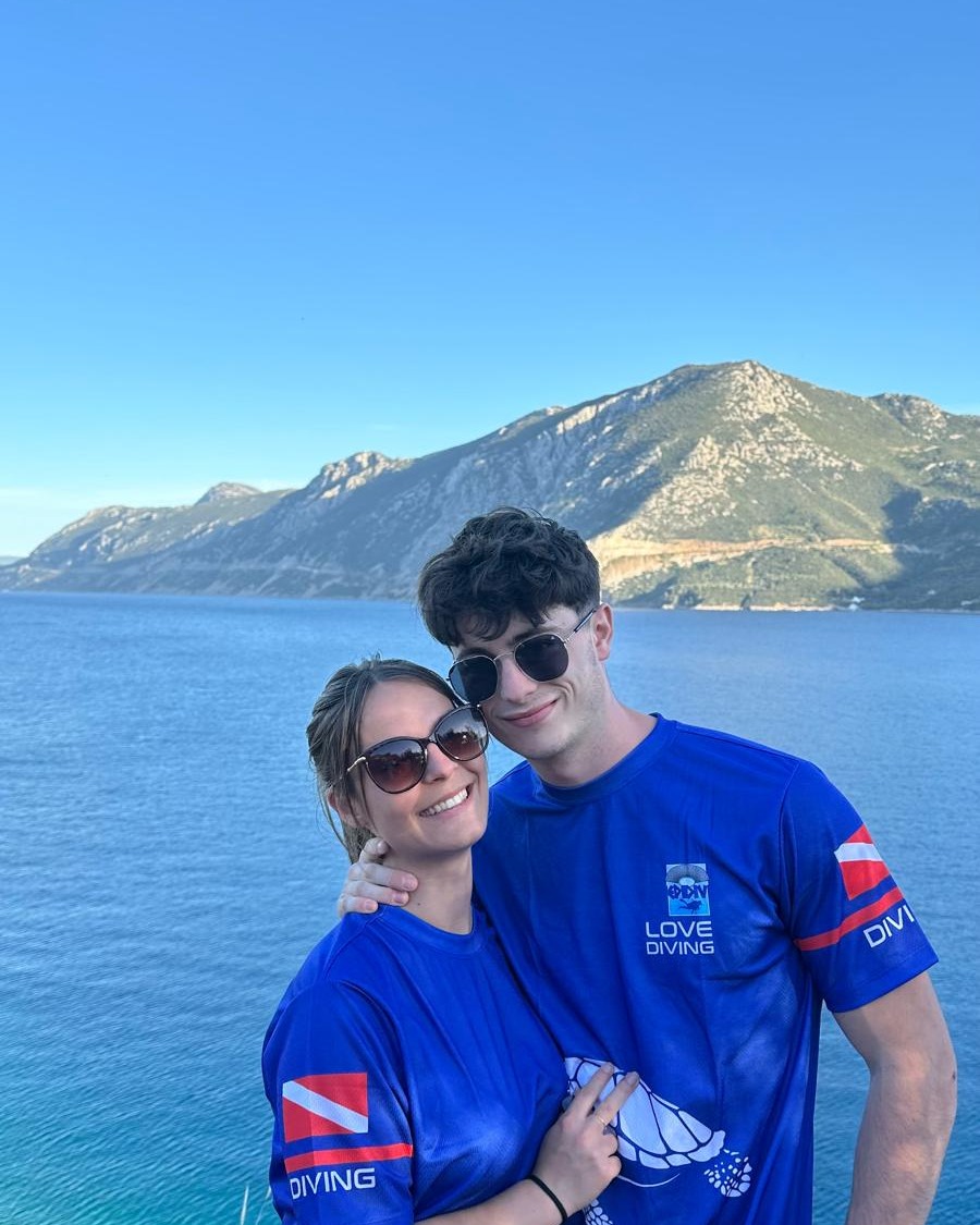 Deux étudiants devant la mer et les montagnes pendant un séjour en Grèce.