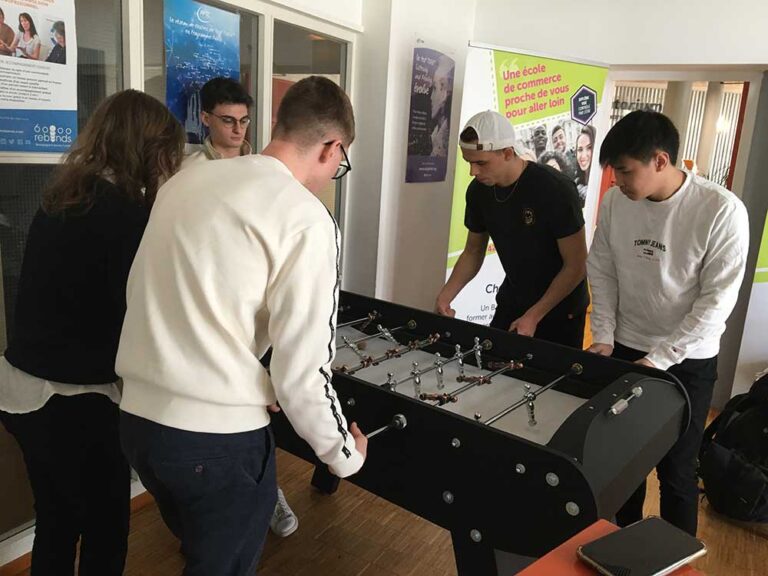 Des étudiants échangent autour d’un baby-foot dans un espace de vie du campus.