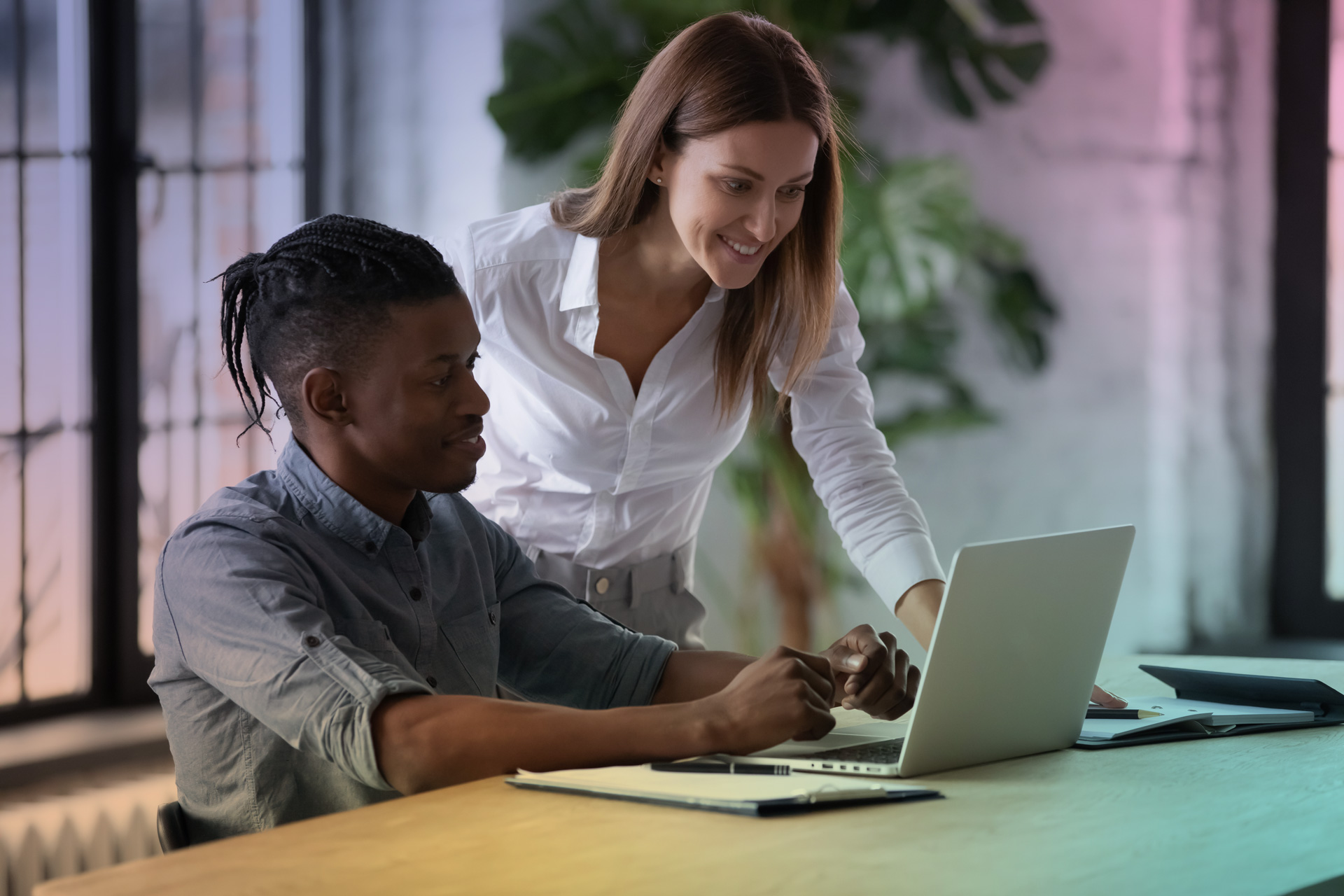 Une professionnelle accompagne un jeune adulte dans son travail sur ordinateur.